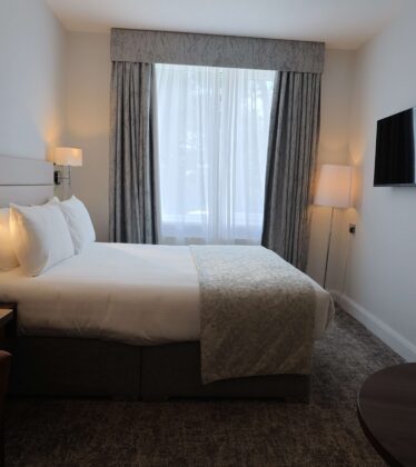 Cosy hotel room with double bed, stylish decor, flat-screen TV, and amenities for a relaxing stay in the heart of the city.